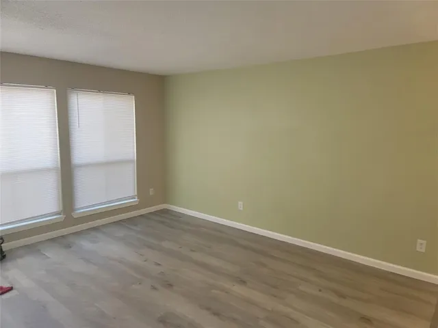 an empty room with wooden floor and door
