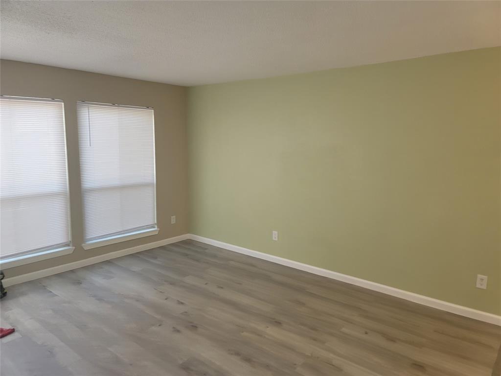 4616 Country Creek Drive, Unit 1176 Dallas, TX 75236 - Photo 9 of 19 an empty room with wooden floor and door
