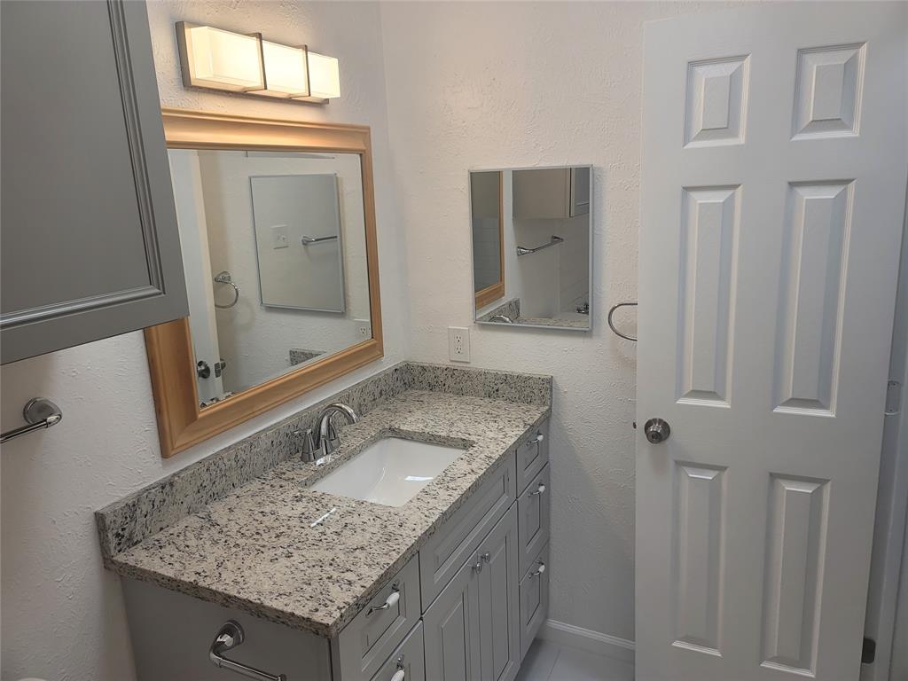 4616 Country Creek Drive, Unit 1176 Dallas, TX 75236 - Photo 10 of 19 a bathroom with a granite countertop sink and a mirror