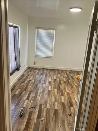 a view of a room with wooden floor and a window