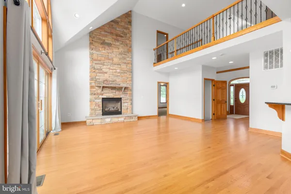 a view of a hallway with wooden floor and a kitchen