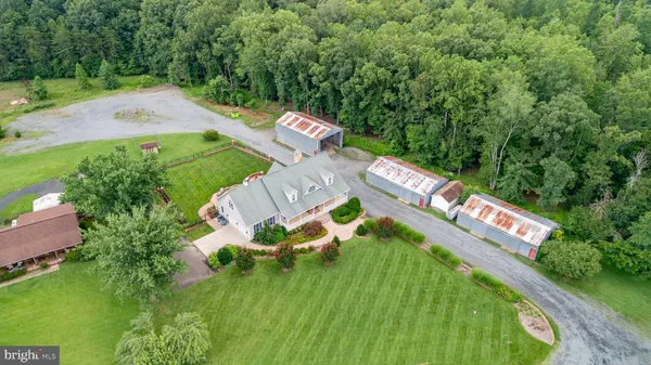 an aerial view of a house with outdoor space patio and trees all around