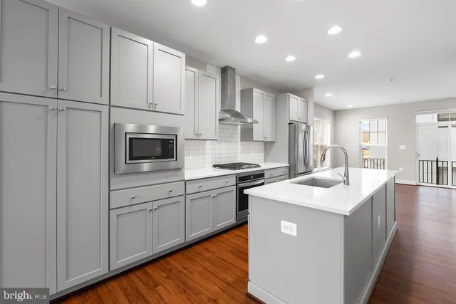 a kitchen with white cabinets appliances and sink