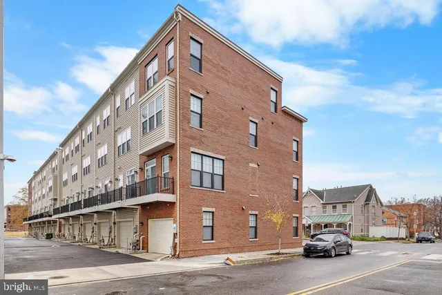 a city street lined with parked cars front of buildings