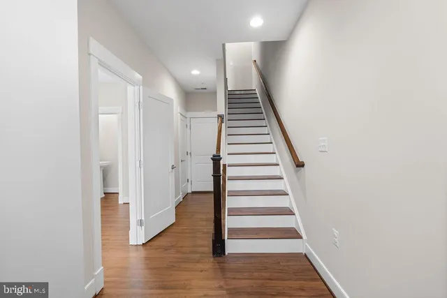 a view of a hallway with wooden floor and entryway