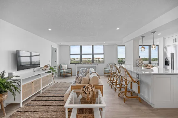 a living room with furniture a flat screen tv and a large window