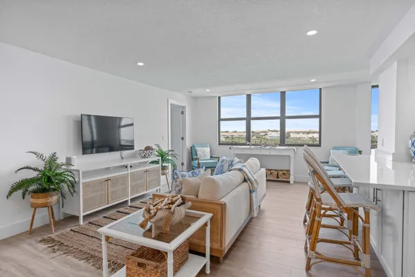 a living room with furniture a flat screen tv and a large window