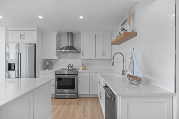 a kitchen with stainless steel appliances granite countertop a sink stove and refrigerator