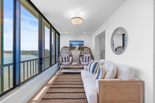 a view of a balcony with furniture and floor to ceiling window