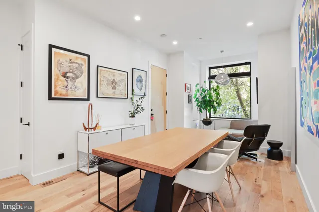 a kitchen with stainless steel appliances a stove a refrigerator a oven and white cabinets with wooden floor