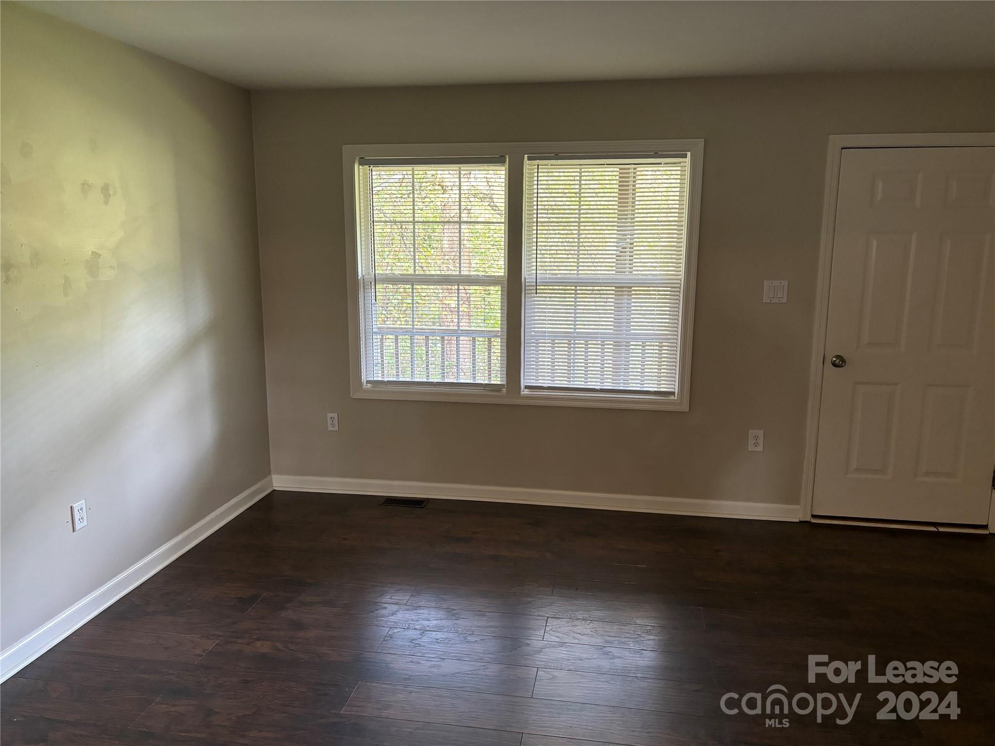276 Isle Of Pines Road, Unit B Mooresville, NC 28117 - Photo 7 of 8 an empty room with wooden floor and windows