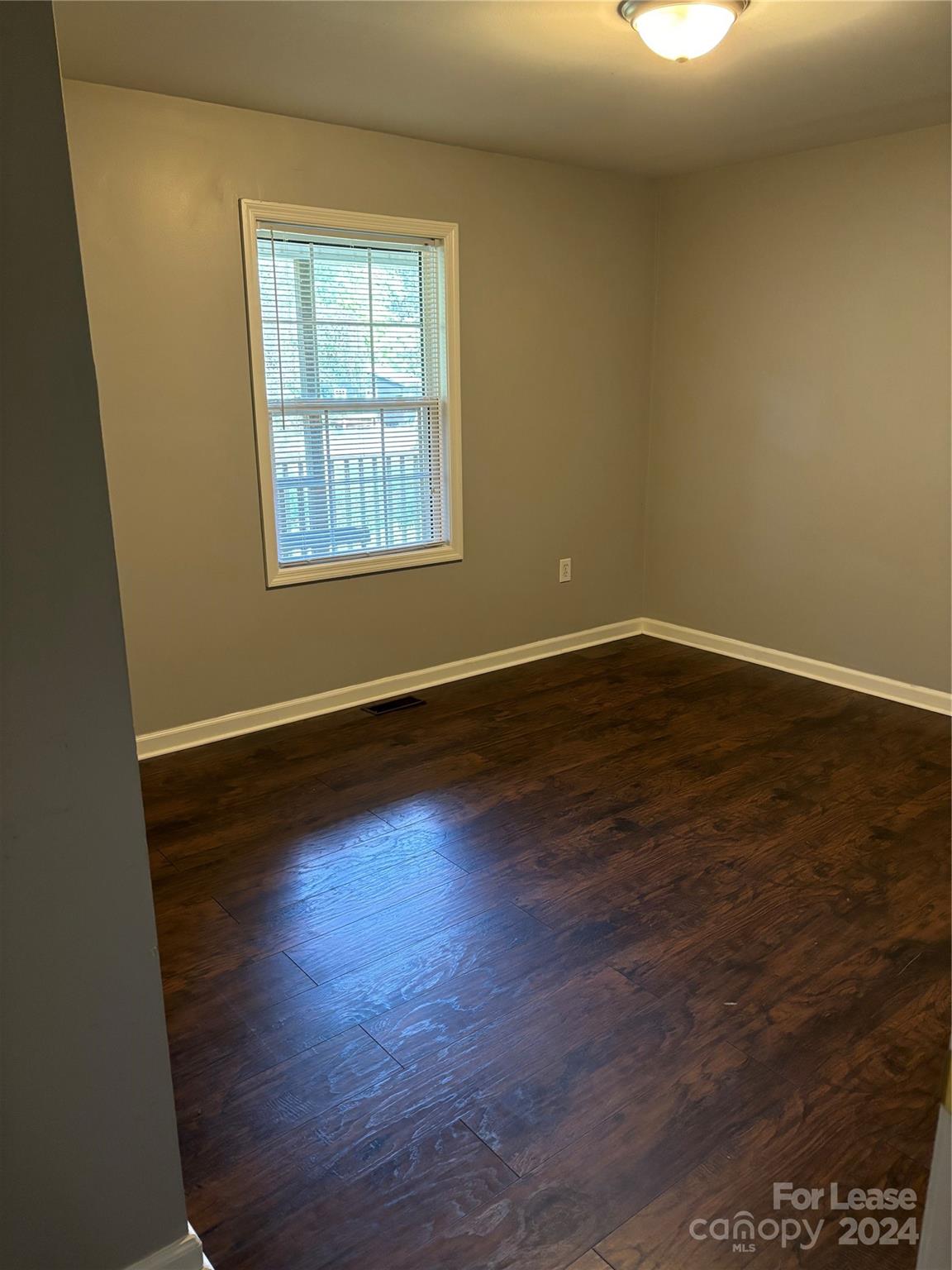 276 Isle Of Pines Road, Unit B Mooresville, NC 28117 - Photo 8 of 8 an empty room with wooden floor and windows