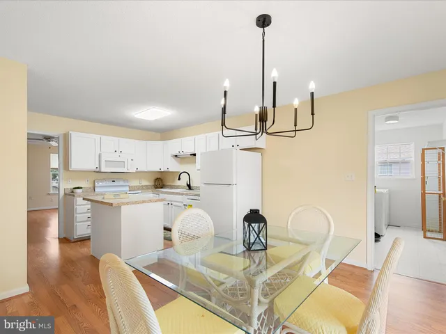 a dining room with furniture a chandelier and wooden floor