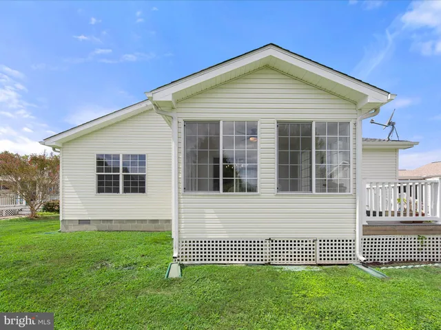 a view of swimming pool with outdoor seating and trees in the background