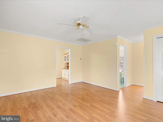a view of a room with wooden floor and ceiling fan