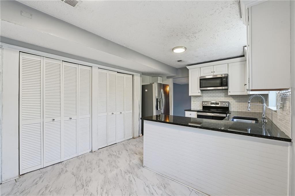 4828 Oak Path Stone Mountain, GA 30088 - Photo 14 of 40 a large kitchen with cabinets