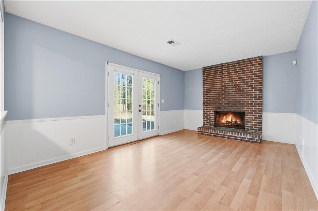 4828 Oak Path Stone Mountain, GA 30088 - Photo 17 of 40 a view of an empty room with wooden floor and a fireplace