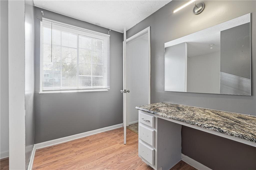4828 Oak Path Stone Mountain, GA 30088 - Photo 25 of 40 a room with granite countertop cabinets and wooden floor