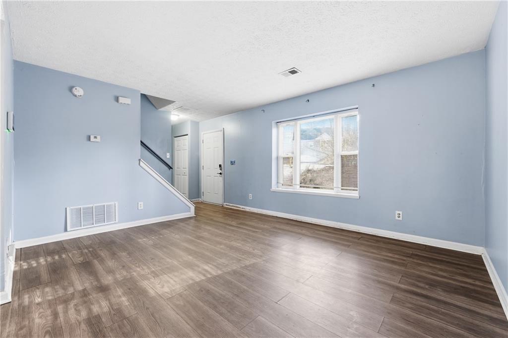 4828 Oak Path Stone Mountain, GA 30088 - Photo 5 of 40 a view of an empty room with wooden floor and a window