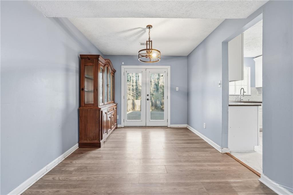 4828 Oak Path Stone Mountain, GA 30088 - Photo 7 of 40 a view of a room with wooden floor windows and a chandelier