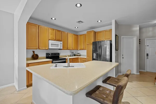 a view of a dining room with furniture a chandelier and large windows