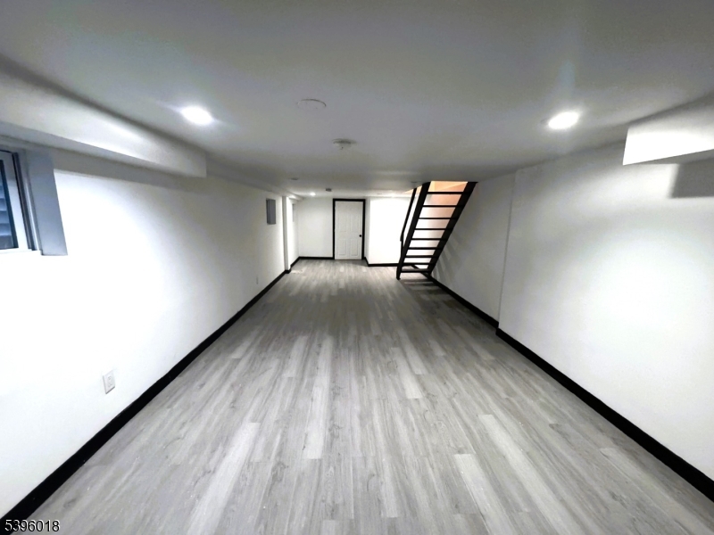 158 Catherine Street, Unit B Elizabeth, NJ 07201 - Photo 13 of 14 an empty room with wooden floor and windows