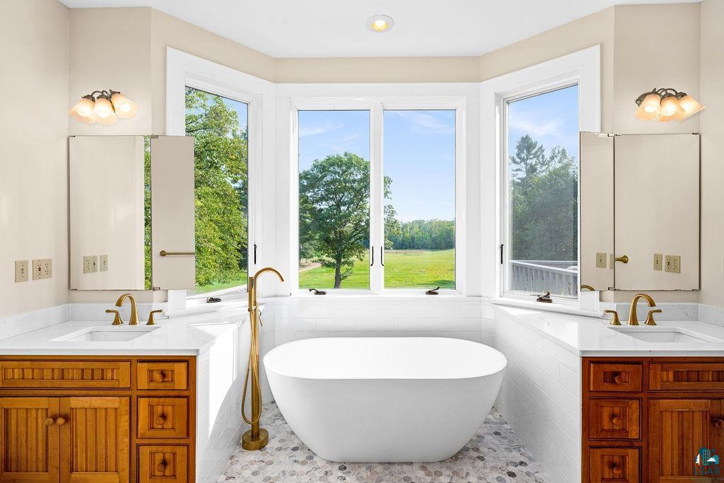 3168 Pioneer Road Barnum, MN 55707 - Photo 25 of 46 This primary bath was recently updated with a free standing tub and quartzite countertops, and a newly tiled shower and glass enclosure. This bathroom with its natural light and giant windows is a wonderful place to get ready for your day.