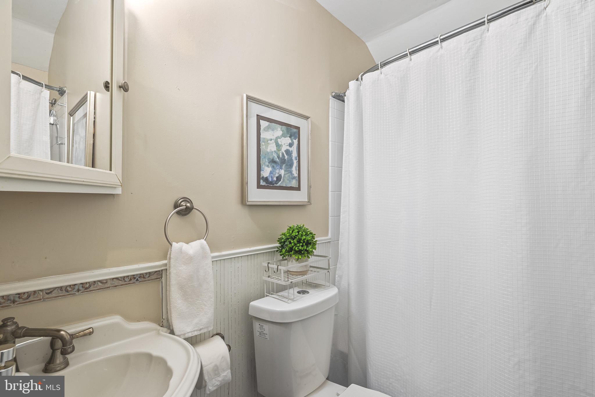 8362 Oakleigh Road Parkville, MD 21234 - Photo 12 of 28 a bathroom with a toilet a sink and a mirror