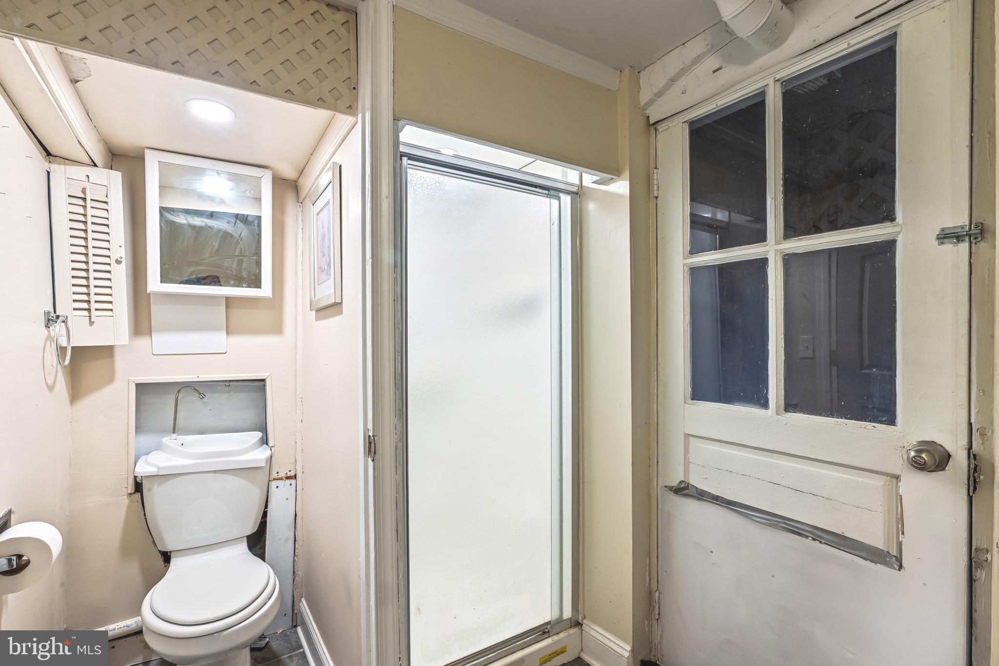 8362 Oakleigh Road Parkville, MD 21234 - Photo 22 of 28 a white toilet sitting next to a bathroom sink