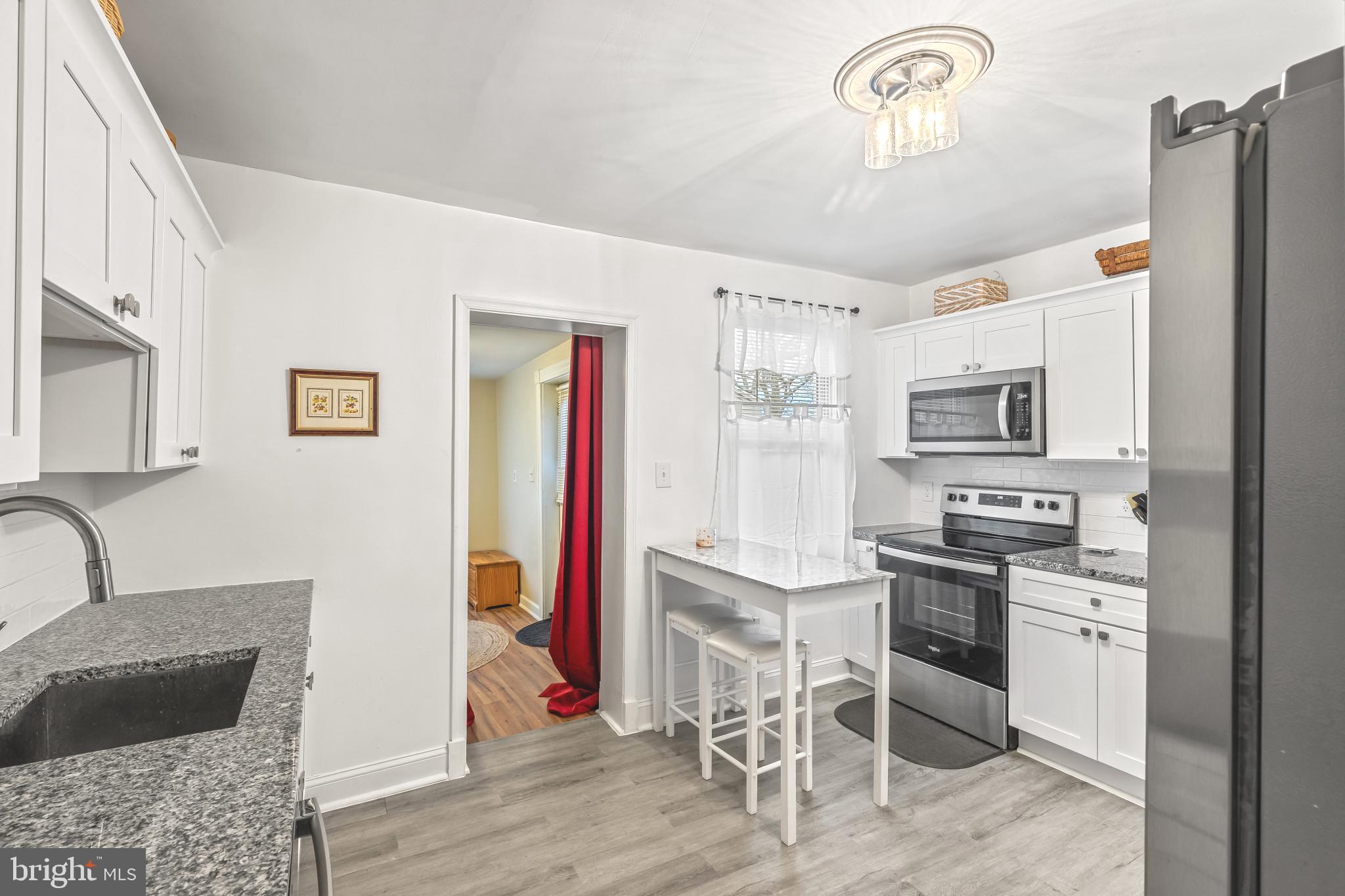 8362 Oakleigh Road Parkville, MD 21234 - Photo 6 of 28 a kitchen with stainless steel appliances granite countertop a refrigerator and stove top oven