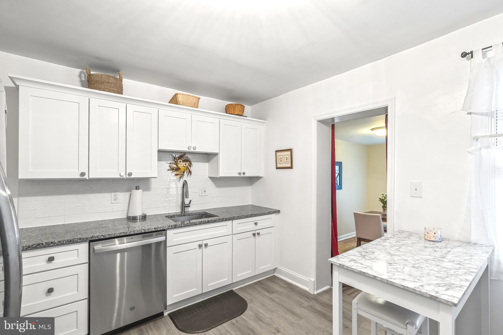 8362 Oakleigh Road Parkville, MD 21234 - Photo 8 of 28 a kitchen with granite countertop white cabinets and white appliances