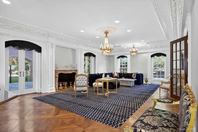 a living room with furniture a fireplace and a chandelier