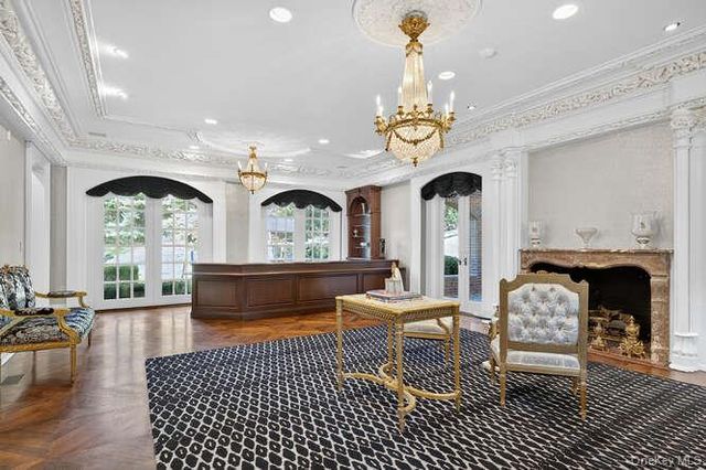 a living room with furniture a fireplace and a chandelier