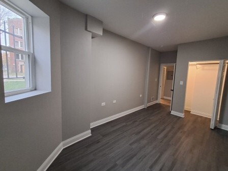 935 West Marquette Road, Unit 9372 Chicago, IL 60621 - Photo 19 of 25 an empty room with wooden floor and windows