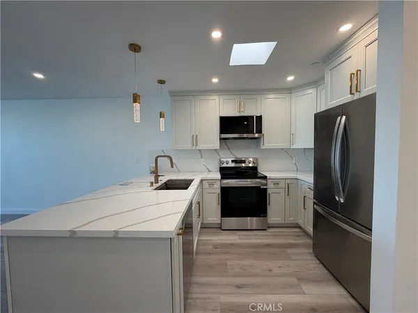 a kitchen with stainless steel appliances a refrigerator stove microwave and sink