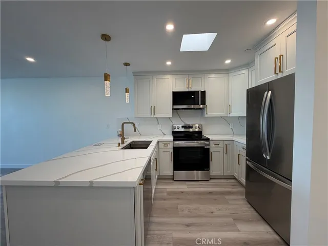 a kitchen with stainless steel appliances a refrigerator stove microwave and sink