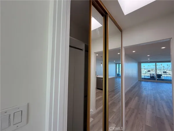 a view of a hallway view with wooden floor and a living room