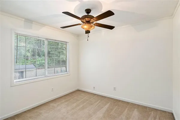 an empty room with window and ceiling fan