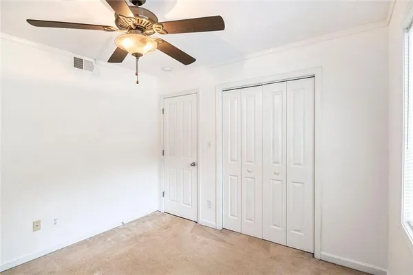 an empty room with a ceiling fan and a window