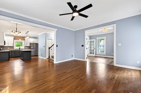 a view of an empty room with wooden floor fireplace and a window