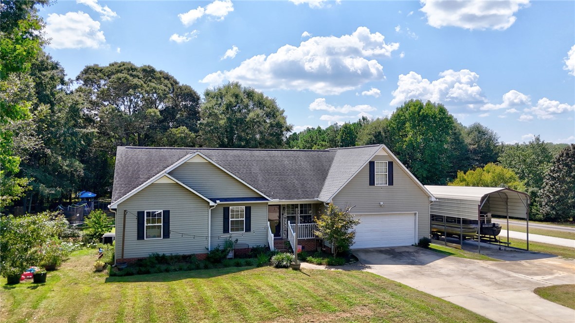 247 Clardy Road Pelzer, SC 29669 - Photo 1 of 34 A classic ranch exterior showcases neutral siding, structured gables, and an attached double garage.