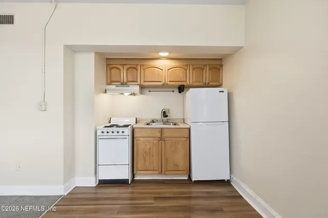 a white stove top oven sitting inside of a kitchen