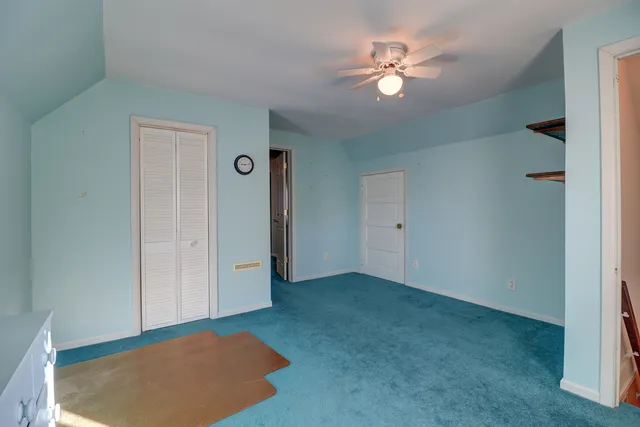 a view of an empty room with a ceiling fan