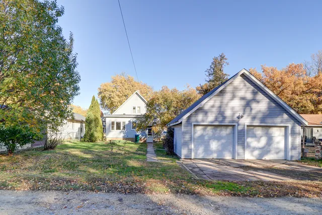 a view of a house next to a yard with big trees