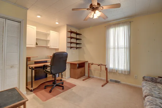 a view of a livingroom with workspace and a window