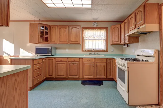 a kitchen with granite countertop white cabinets and white appliances