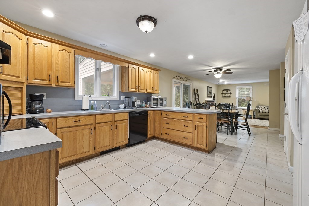 3 Daniels Road Medway, MA 02053 - Photo 12 of 28 a kitchen with stainless steel appliances granite countertop a stove a sink a oven with a dining table and chairs