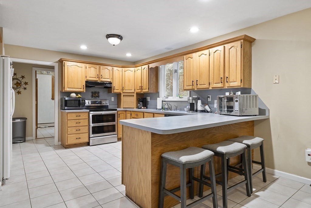 3 Daniels Road Medway, MA 02053 - Photo 13 of 28 a kitchen with stainless steel appliances granite countertop a stove a sink a microwave and a refrigerator