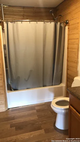 a bathroom with a toilet and a shower curtain