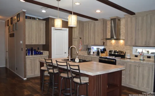 a kitchen with granite countertop a table chairs stove a refrigerator and cabinets